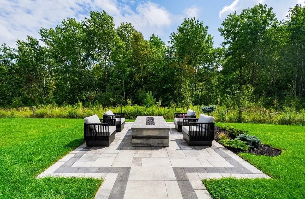 Symmetrical fire-table terrace framed by lawn and woodland